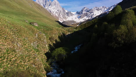 Drone-shot-following-a-mountain-stream-then-rising-to-reveal-the-Georgian-Dolomites-in-the-Caucasus-mountains