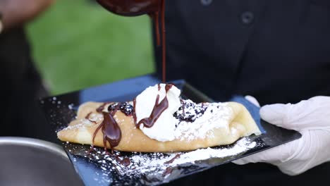 Hot-Fudge-Chocolate-Syrup-being-Drizzled-by-Chef-onto-Delicious-Crepe