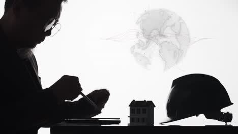 An-engineer-or-architect-designing-a-home-for-a-global-market---silhouette-with-a-rotating-graphic-of-the-Earth