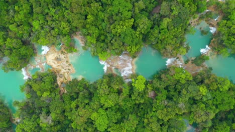 Aerial:-high-top-down-view-of-waterfall-cascades-in-tropical-rainforest
