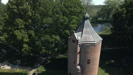Drone-fly-by-of-a-small-magical-tower-of-Castle-Loevestein-with-birds-flying-over-on-a-bright-sunny-day-in-the-Netherlands
