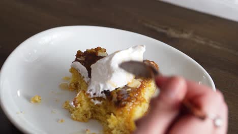Female-Hand-While-Eating-Sweet-Banana-Cake-Topped-With-Whip-Cream