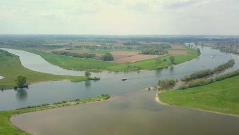 Luftdrohnenansicht-Des-Schönen-Flusses-Mit-Einigen-Vorbeifahrenden-Booten-In-Den-Niederlanden