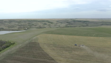 Wide-aerial-view-of-tractor-with-seeder-equipment-sowing-crops,-Canada