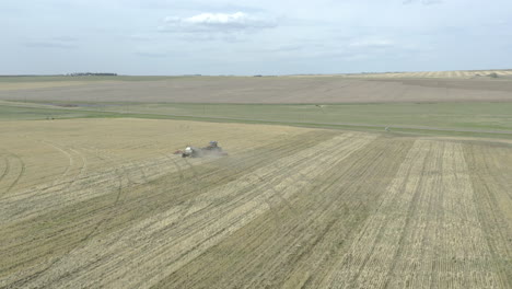 Precision-farming-with-tractor-seeding-new-crop-in-straight-lines,-aerial