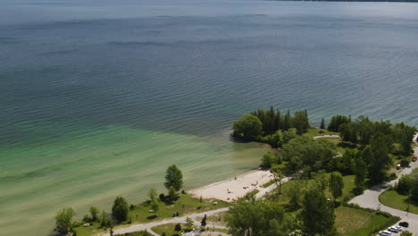 Aerial-orbit-shot-of-Innisfil-beach-and-revealing-Lake-Simcoe-in-southern-Ontario,-Canada