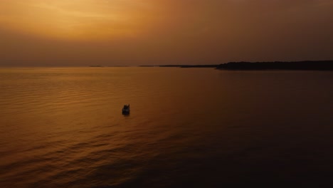 Fliegen-Sie-Einen-Kreis-Um-Eine-Ferienyacht,-Ein-Schiff,-Ein-Fischerboot,-Durch-Eine-Wunderschöne-Orangefarbene-Sonnenuntergangsküstenbucht-Im-Idyllischen-Adriatischen-Mittelmeerozean-An-Der-Kroatischen-Küste