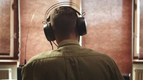 Military-radio-operator-using-headphones-before-speech,-back-view-of-head