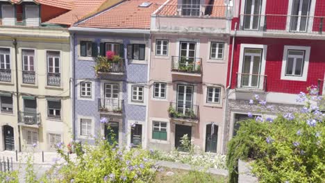 Schwenkaufnahme-Von-Wunderschönen-Gebäuden-Der-Altstadt-Von-Lissabon-Mit-Einem-Blumenbeet-Im-Vordergrund
