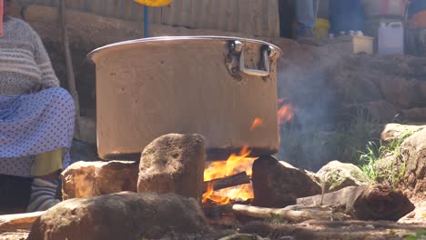Big-caldron-for-cooking-the-meat-for-the-wedding-party-in-Ethiopia,-Addis-Ababa,-using-the-traditional-way,-and-putting-coal-and-dirt-around-the-caldron-to-prevent-it-from-burning