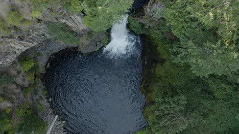 Drone-shot-of-Toketee-Falls-in-Oregon-slowly-descending,-panning-upwards
