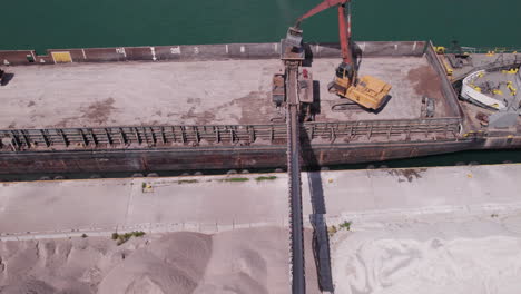 Top-View-Of-Heavy-Machine-Pouring-Out-Sand-At-The-Kingsville-Marina-From-Gravel-Ship