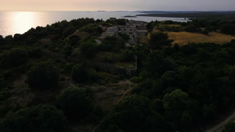 Cinematic-aerial-view-drone-above-a-historic-World-War-I-fortification-seaside-fort-fortress-by-the-idyllic-Adriatic-mediterranean-sea-ocean-with-blue-water-and-hidden-beaches-by-sunset-in-summer