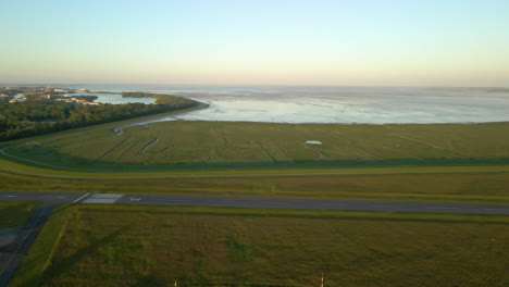 Empty-Runway-Of-JadeWeser-Airport-In-Sande,-Germany-With-View-Of-Jade-Bight-In-Background