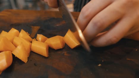 Chopping-carrots-on-wooden-board