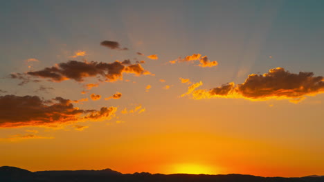 The-sun-sets-behind-the-mountains-in-golden-splendor-as-another-day-comes-to-an-end---static-time-lapse-with