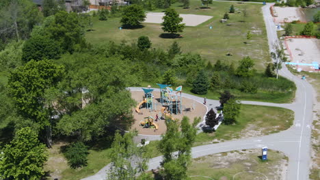 Aerial-orbit-shot-revealing-playground-on-Innisfil-beach-park-in-Lake-Simcoe-coast,-Ontario