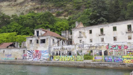 Ruinas-Industriales-Abandonadas-Con-Muchos-Graffiti-Al-Otro-Lado-Del-Río-En-Lisboa,-Almada,-Portugal
