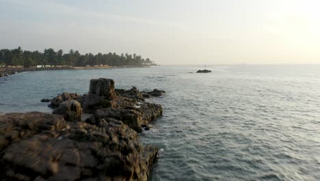 Dawn-bright-sunlight-above-sea-with-rocky-shore-at-Sri-Lanka,-Salli