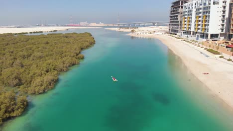 Aerial-descending-over-Al-Reem-mangroves,-approaching-person-in-kayak