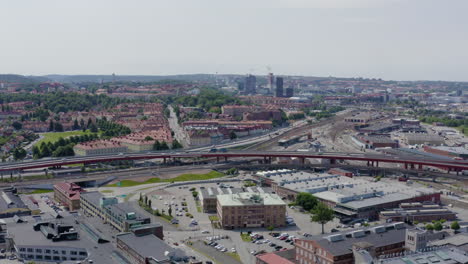 Busy-interstate-heavy-traffic-driving-through-freeway-Gothenburg-Sweden-Scandinavian-city-population-going-to-work-transporting-goods-cars-buses-jam-police-tram-people-aerial-Sverige-drone-wide-view
