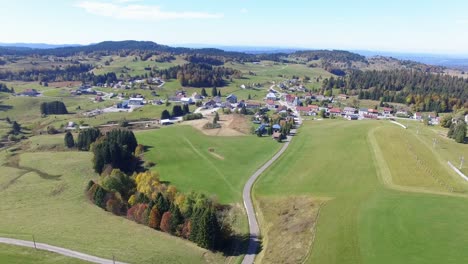 Aerial-flight-showing-village-La-Pesse-and-Jura-mountains-in-background-in-summer,France