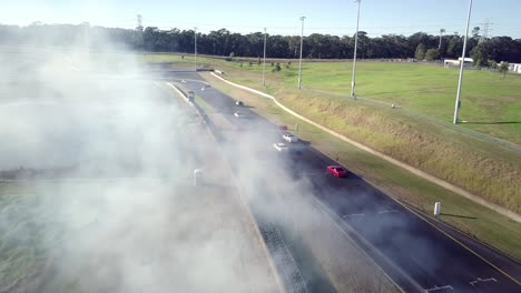 Cars-Drifting-Battle-On-Race-Track-With-Smoke-At-Sydney-Motorsport-Park-In-Australia---aerial-drone-shot