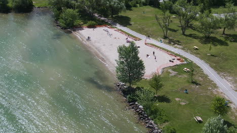 Aerial-view-of-people-relaxing-at-Innisfil-beach-park-on-a-sunny-day,-Ontario,-Canada