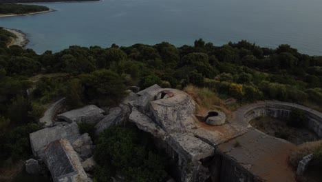 Fast-Cinematic-aerial-view-drone-circle-above-a-historic-World-War-I-fortification-seaside-fort-fortress-by-the-idyllic-Adriatic-mediterranean-sea-ocean-with-blue-water-and-hidden-beaches-in-summer