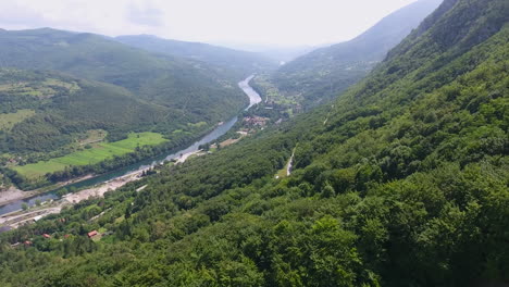 Ein-Drohnenflug-über-Eine-Landschaftlich-Reizvolle-Landschaft-Mit-Riesigen-Bergen,-Einem-Fluss-Und-Einem-Tal