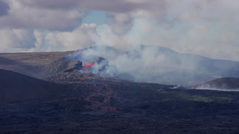 Helicopter-flying-around-spewing-Volcano-after-Eruption,-observing-rocky-area-in-Iceland