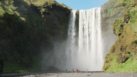 Tourists-admiring-epic-Icelandic-waterfall-Skogafoss