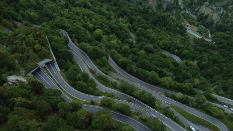Aerial-view-drone-flight-at-the-idyllic-mountain-serpentine-road-Plöckenpass-in-the-natural-Austrian-and-Italian-alps-in-summer-with-green-forest-trees-in-nature-and-travel-vacation-cars-on-the-street
