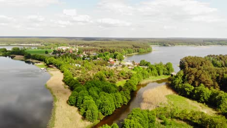 Panoramic-View-Of-Nature-Park-With-Small-Community-Surrounded-By-Lake-And-Vegetation-In-Styporc,-Gmina-Chojnice,-Poland