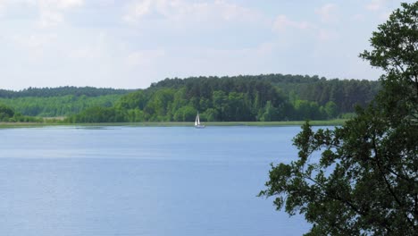Malerischer-Blick-Auf-Die-Yacht,-Die-Auf-Einem-Friedlichen-See-In-Der-Nähe-Des-Dorfes-Charzykowy-In-Nordpolen-Kreuzt