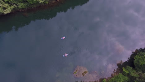 Two-beautiful-kayak-boats-in-the-river,-top-aerial-view