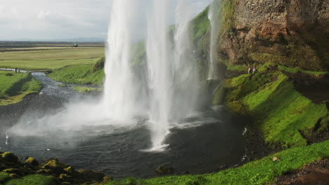 Touristen,-Die-Den-Wunderschönen-Seljalandsfoss-wasserfall-In-Island-Erkunden