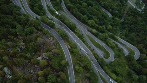 Flying-along-the-idyllic-mountain-serpentine-road-Plöckenpass-in-the-natural-Austrian-and-Italian-alps-in-summer-with-green-forest-trees-and-cars-on-the-street