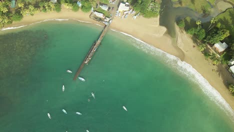 Ascending-aerial-rocket-view-of-Parlatuvier-beach-and-jetty-with-fishing-boats-anchored-in-her-blue-waters