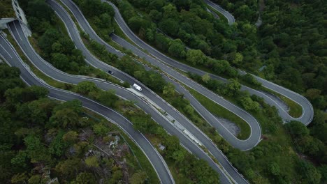 Flying-above-the-idyllic-mountain-serpentine-road-Plöckenpass-in-the-natural-Austrian-and-Italian-alps-in-summer-with-green-forest-trees-and-cars-on-the-street