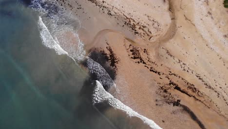 Aerial-Top-Down-View-Of-Waves-Breaking-On-Charmouth-Beach-In-Dorset