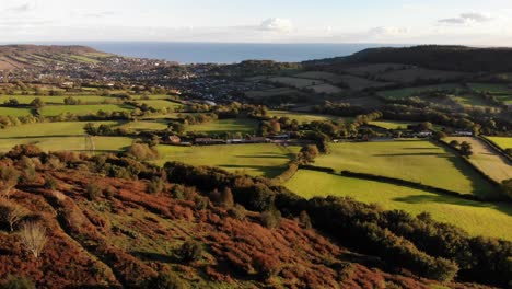 Aerial-Over-Fire-Beacon-Hill-towards-Sidmouth-During-Evening-Sunset-In-Devon