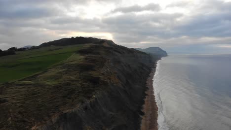 Aerial-View-Along-Jurassic-Coastline-Cliffs-Along-Charmouth-Beach-In-The-Morning