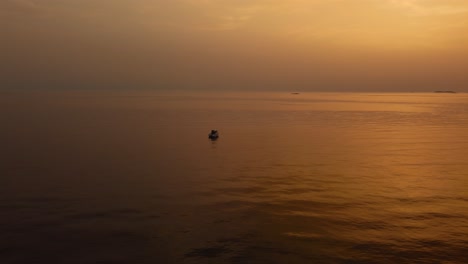 Drohnen-Luftaufnahme,-Die-In-Richtung-Eines-Ferienyacht-Schiffsfischerboots-Durch-Die-Wunderschöne-Orangefarbene-Sonnenuntergangsküstenbucht-Im-Idyllischen-Adriatischen-Mittelmeerozean-An-Der-Kroatischen-Küste-Mit-Inseln-Fliegt