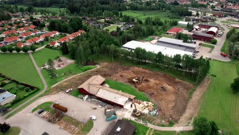 Excavator-At-Construction-Site-in-Villa-Area,-Nordic-Country,-Aerial-Circling