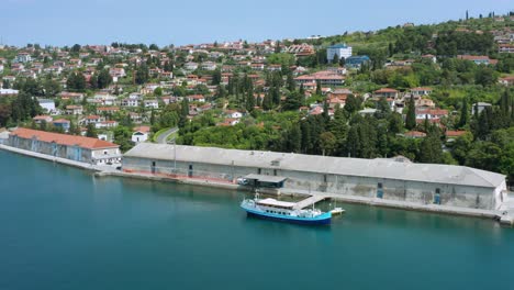 Slow-aerial-shot-gently-pulling-away-from-a-dock-and-village-along-the-Slovenian-Riviera
