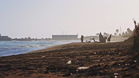 Strand-Mit-Menschen-Auf-Der-Silhouette-Im-Hintergrund