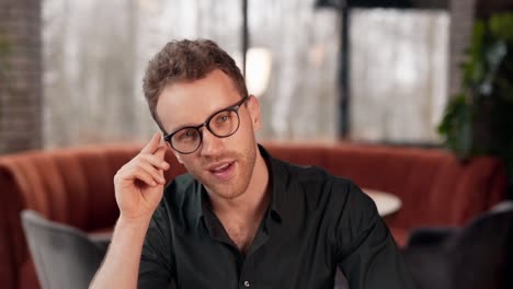 Closeup-portrait-of-a-curly-young-man-wearing-glasses