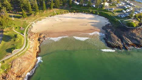Waves-On-Sandy-Shore-Of-Horseshoe-Bay-Beach-During-Golden-Hour---Point-Briner-Peninsula-At-South-West-Rocks-On-Mid-North-Coast-Of-NSW,-Australia