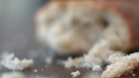 Macro-push-in-motion-to-bring-a-piece-of-leftover-bread,-half-eaten-in-focus